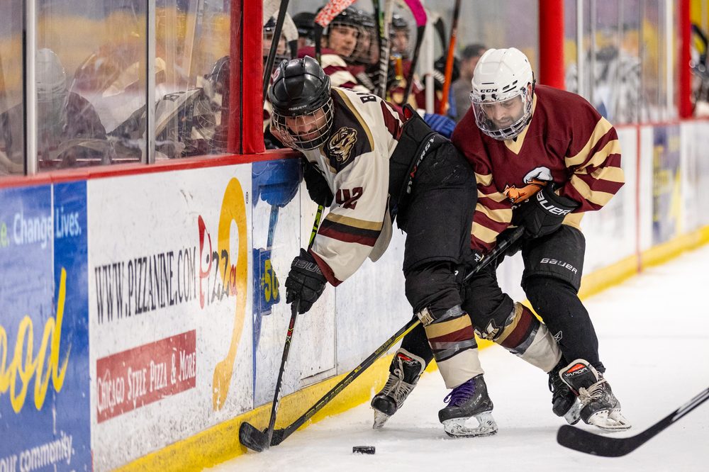 Players battling for the puck along the boards